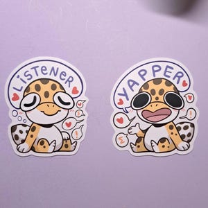 Peut inclure: Deux autocollants de lézard léopard de dessin animé avec des bulles de dialogue. Un autocollant dit "Listener" et l'autre dit "Yapper".