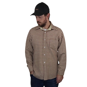 Peut inclure: Une chemise boutonnée à carreaux marron et beige avec une poche poitrine et une casquette de baseball noire. La chemise a des manches longues et un col. La casquette a une visière incurvée et un petit logo.