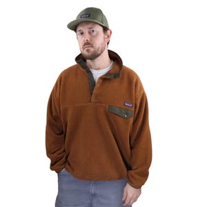 Puede incluir: Una taza de cerámica blanca con un asa negra y el texto "But First, Coffee" en negrita negra. La taza está sobre un fondo borroso. La taza mide aproximadamente 10 cm de altura.