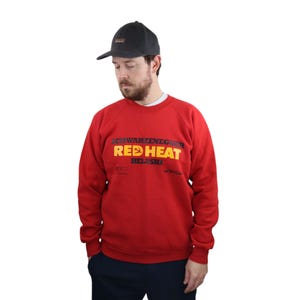 May include: Red sweatshirt with a black and yellow graphic print that says "Schwarzenegger Red Heat Belushi".