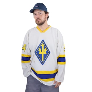 May include: Cream-colored hockey jersey with blue and yellow accents. Features a blue and yellow diamond-shaped emblem with a trident design. The number 4 is on the left sleeve. A blue baseball cap completes the look.