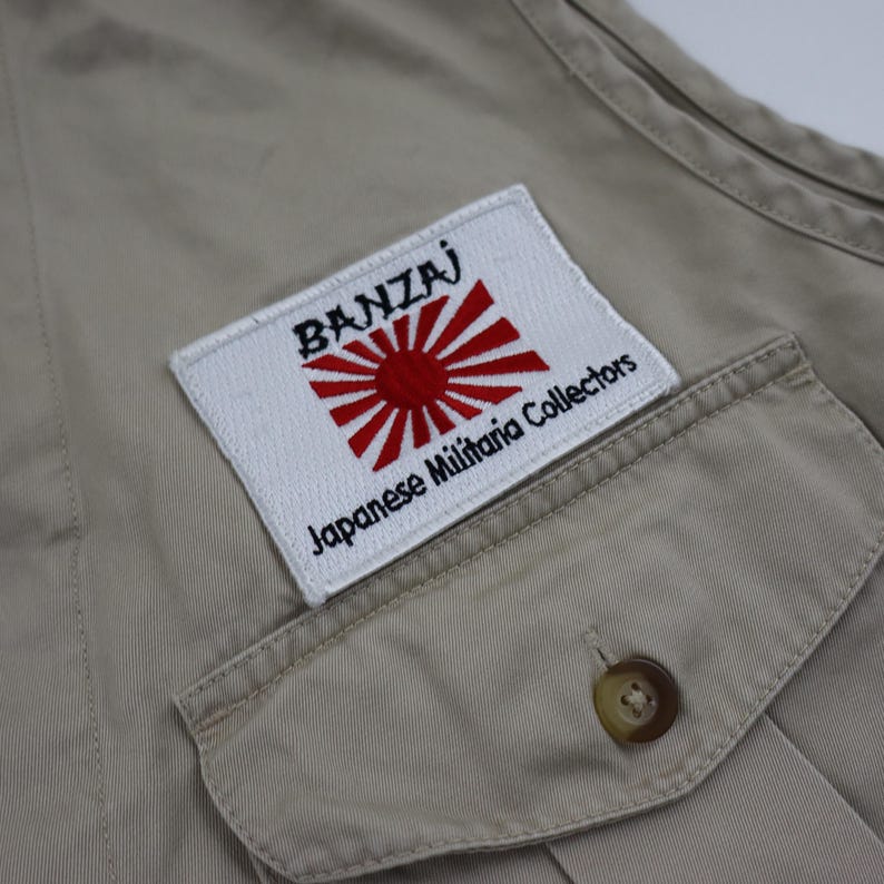 May include: A beige cotton vest with a white patch that says "BANZAI" and "Japanese Militaria Collectors" with a red and white rising sun emblem.