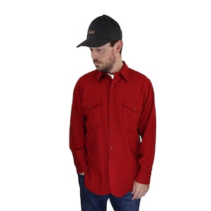 Può includere: Una camicia rossa a maniche lunghe con bottoni, due tasche sul petto e un berretto da baseball nero.
