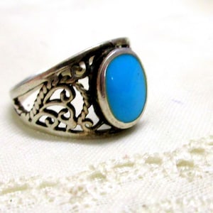 Könnte beinhalten: Ein silberner Ring mit einem blauen Türkis-Stein, der in einem filigranen Design gefasst ist.
