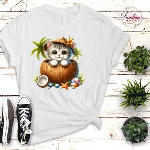 Könnte beinhalten: Weißes T-Shirt mit einer Cartoon-Katze in einer Kokosnussschale, die einen Strohhut trägt. Das Design umfasst Palmen, einen Strandball und einen Seestern. Das T-Shirt hat einen V-Ausschnitt und kurze Ärmel.