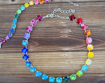 May include: A rainbow crystal necklace with a silver chain. The necklace is made of round, faceted crystals in a rainbow of colours, including red, orange, yellow, green, blue, indigo, and violet.