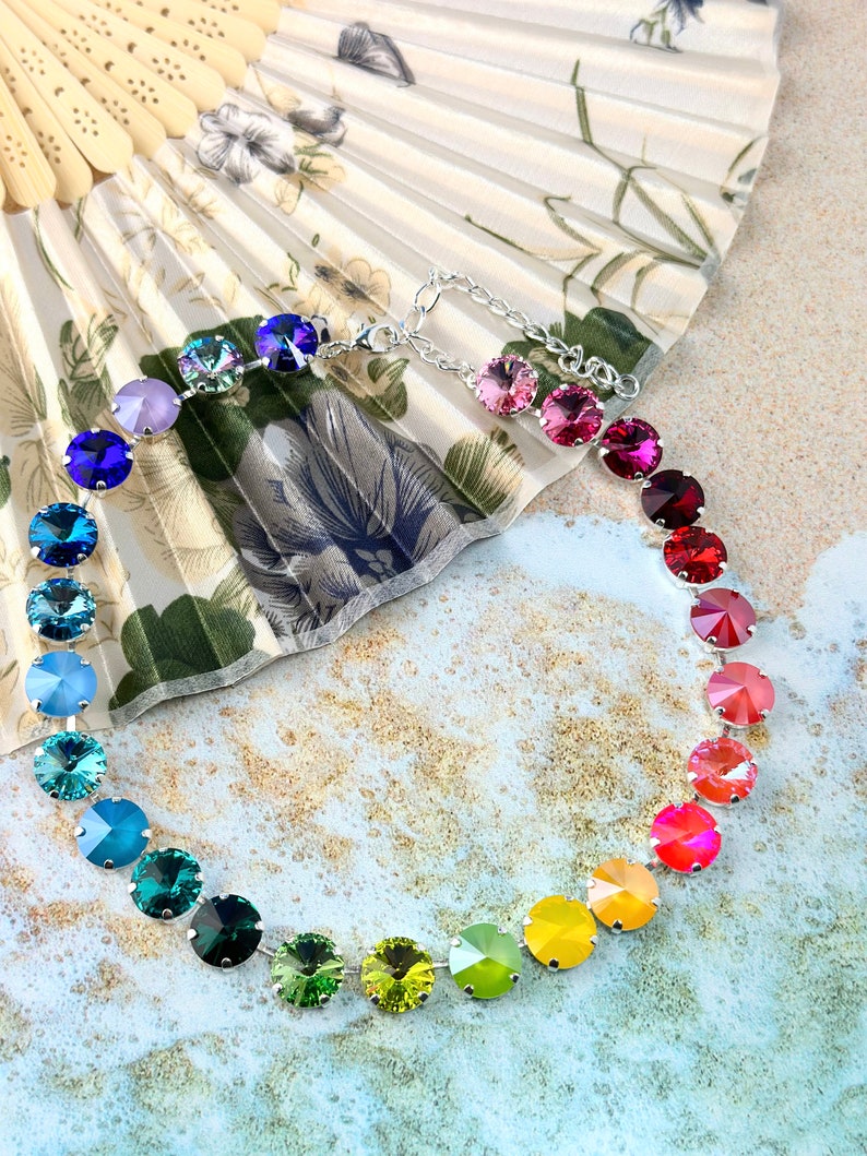 May include: A rainbow crystal necklace with a silver chain and round, faceted crystals in shades of purple, blue, green, yellow, orange, and red.