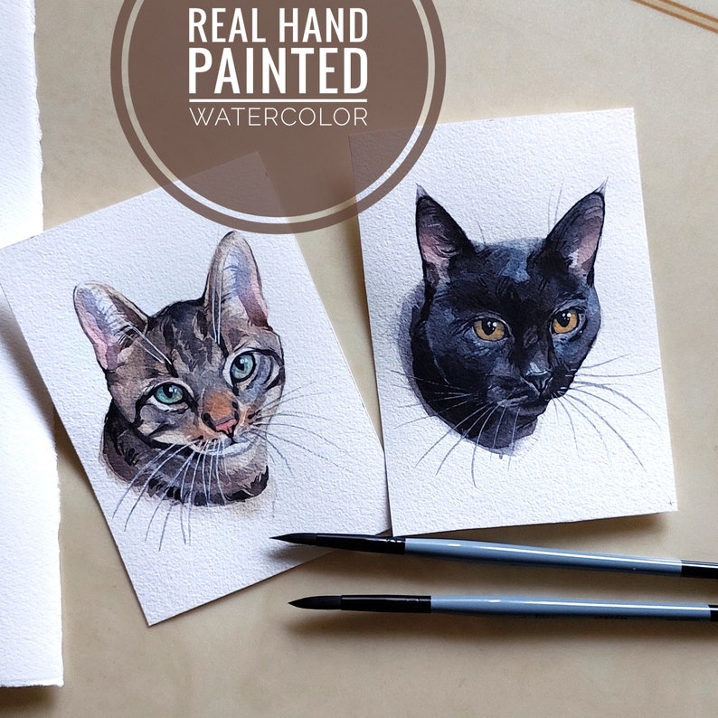 K&ouml;nnte beinhalten: Zwei Aquarellbilder von Katzen auf wei&szlig;em Karton. Die Katze links ist eine getigerte Katze mit gr&uuml;nen Augen. Die Katze rechts ist schwarz mit gelben Augen. Beide Katzen schauen den Betrachter an. Die Bilder sind mit "Real Hand Painted Watercolor" signiert.