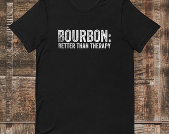 May include: Black t-shirt with white text that reads "BOURBON: BETTER THAN THERAPY".