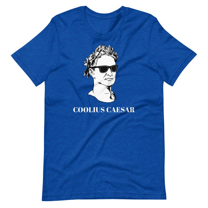 May include: A royal blue t-shirt featuring a white graphic of a bust of a man wearing sunglasses and a laurel wreath. The text "COOLIUS CAESAR" is printed below the graphic.
