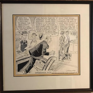 May include: Framed black and white cartoon titled "Sheridan's Ride" by J.R. Williams. The cartoon depicts several men in a workshop setting, with speech bubbles containing text about experience and craftsmanship.