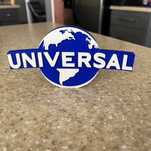 May include: A blue and white 3D printed Universal Studios logo with the globe and the word "UNIVERSAL" in white lettering.