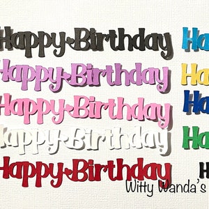 May include: A collection of colorful die-cut paper phrases that read "Happy Birthday." The words are in various colors, including black, purple, pink, white, red, blue, yellow, and green. The words are in a cursive font. The words "Witty Wanda's Creations" are at the bottom.