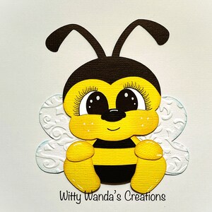 May include: A cute cartoon bee with big eyes, black and yellow stripes, and white wings. The bee is sitting on its bottom with its legs tucked in. The bee is smiling and has a black nose.