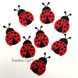May include: Seven red and black ladybug cutouts with black antennae and white polka dots. The ladybugs are made of paper and are perfect for crafts or decorations.