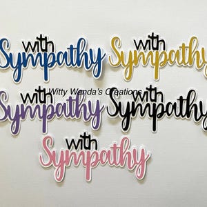 May include: A collection of die-cut phrases, each reading "with Sympathy" in a cursive font. The phrases are in various colors, including blue, gold, purple, black, and pink, with a white border.