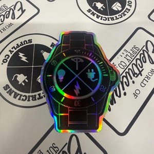May include: A holographic sticker shaped like a wristwatch with a black face. The watch face features four quadrants containing a lightbulb, an electrical plug, a lightning bolt, and a compass icon. The bezel displays numbers 20, 30, 40, and 50.
