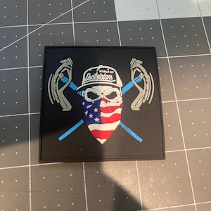 Könnte beinhalten: Ein schwarzer Patch mit einem weißen Schädel, der einen schwarz-weißen Hut trägt, auf dem "World of Electricians" steht. Der Schädel trägt ein rot-weiß-blaues Bandana. Zwei gekreuzte blaue und weiße Werkzeuge befinden sich hinter dem Schädel.