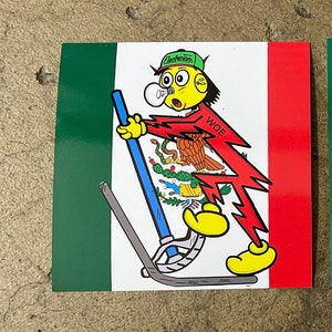May include: A cartoon character wearing a green hat with the word "Electricians" on it, a red shirt with a lightning bolt and the word "WOE", and yellow shoes, is standing on a stick with a blue handle. The character is holding a light bulb in their mouth and is standing in front of a green, white, and red flag.