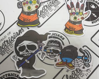 Könnte beinhalten: Eine Sammlung von Aufklebern mit Cartoon-Illustrationen. Designs umfassen eine Hand mit Messern, eine Hand mit Krallen, einen Sensenmann und einen Schädel mit Hut. Die Aufkleber tragen den Text "WORLD OF ELECTRICIANS SUPPLY CO. BRAND Est. 2016" und "WOE".