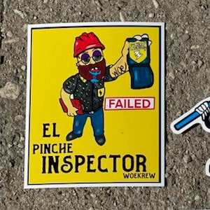 May include: A yellow sticker with a cartoon illustration of a person wearing a red hard hat and holding a blue badge that says "FAILED". The text on the sticker says "El Pinche Inspector" and "Woekrew".