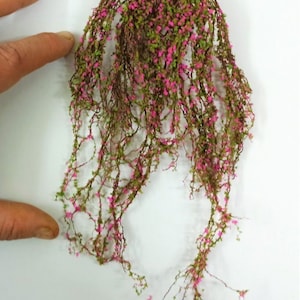 Puede incluir: Una larga hebra de vegetación artificial con flores rosas, ideal para añadir un toque de naturaleza a maquetas de trenes o escenas en miniatura.