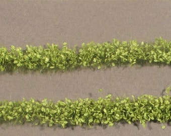 May include: Two rows of green foliage, resembling a hedge or border, with a ruler measuring 1 cm in the top right corner.