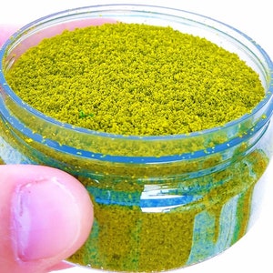 May include: A clear plastic jar filled with bright yellow glitter. The glitter is fine and has a slightly iridescent sheen.