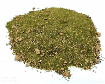 Op de afbeelding: Een close-up van een hoop groene en bruine aarde, waarschijnlijk voor gebruik in een terrarium of miniatuurtuin.