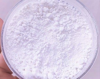 May include: A white powder in a clear glass jar. The powder is made up of small, white granules.
