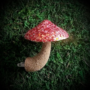 May include: A red and gold glitter mushroom shaped night light with a brown plug-in base.