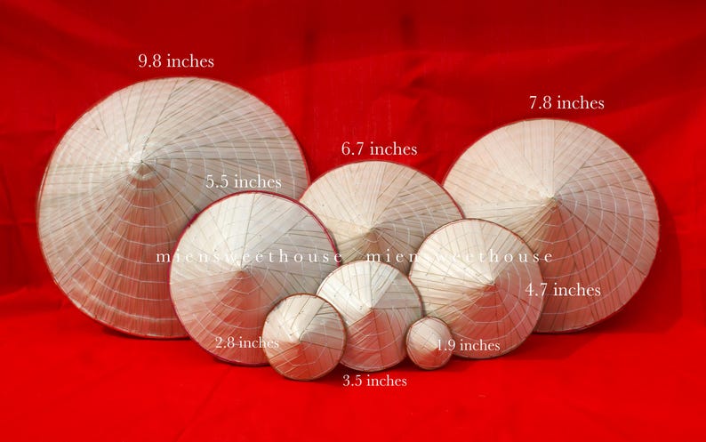 May include: A collection of conical straw hats of varying sizes, ranging from 1.9 inches to 9.8 inches in diameter, displayed against a red background. The hats are made of woven straw and have a traditional conical shape.