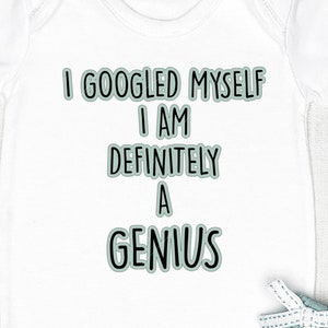 Puede incluir: Un body blanco para bebé con mangas cortas y el texto "Me he buscado en Google Soy definitivamente un genio" en negro con un contorno verde.