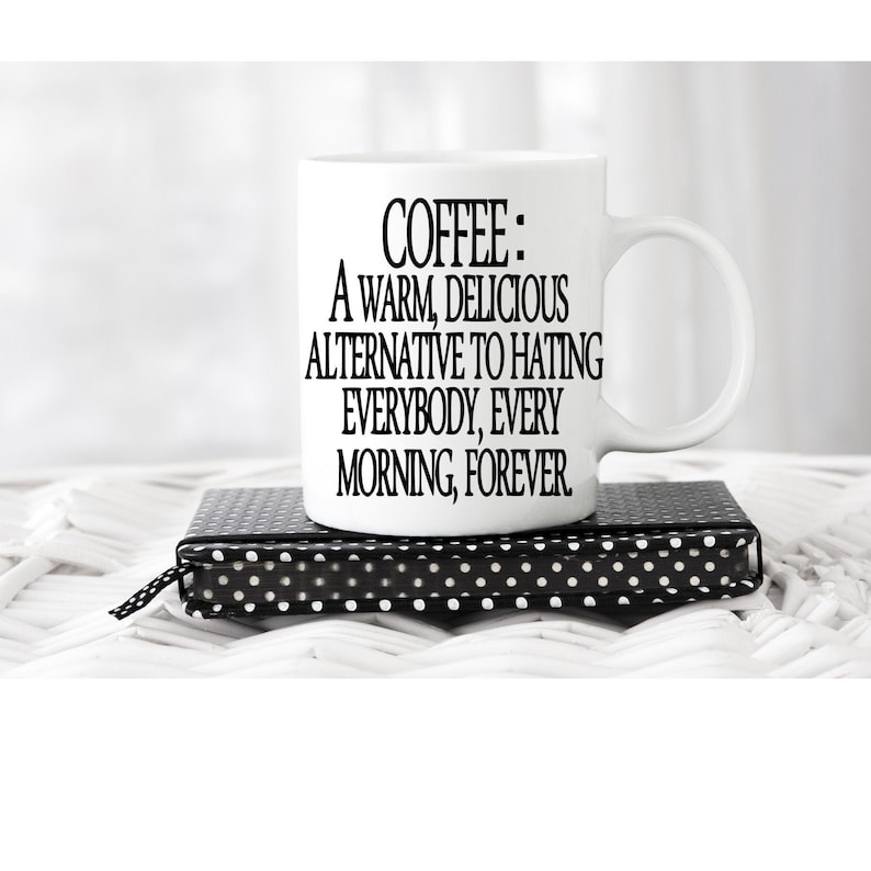 K&ouml;nnte beinhalten: Wei&szlig;e Keramik-Kaffeetasse mit schwarzem Text, der "COFFEE: A WARM, DELICIOUS ALTERNATIVE TO HATING EVERYBODY, EVERY MORNING, FOREVER" lautet.