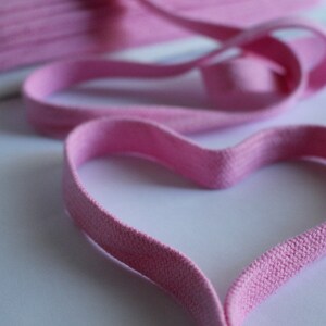 Könnte beinhalten: Rosa elastisches Band in Herzform. Das elastische Band ist aus weichem, dehnbarem Material und eignet sich perfekt für Bastelarbeiten, Haargummis oder andere Projekte.