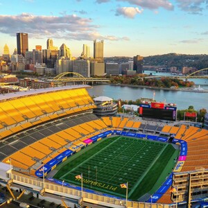 Peut inclure: Vue aérienne du Heinz Field, un grand stade extérieur avec un terrain de football vert, des sièges jaunes et un grand écran vidéo. Le stade est situé à Pittsburgh, en Pennsylvanie, avec la ville en arrière-plan.