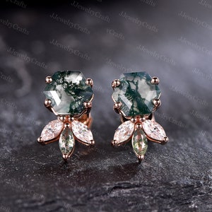 May include: A pair of rose gold earrings with green agate stones and clear cubic zirconia accents. The stones are set in a hexagonal shape and the earrings have a delicate, feminine design.