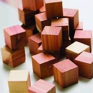 May include: A pile of small, wooden cubes in various shades of brown. The cubes are made of cedar wood and have a natural, rustic look.
