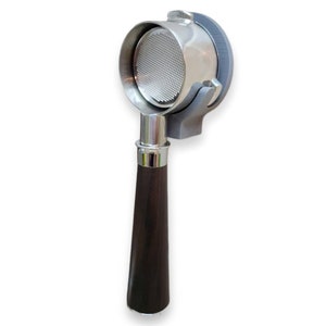 May include: A stainless steel portafilter with a dark brown wooden handle. The portafilter is held in a gray holder. The filter basket is visible inside the portafilter. The handle is a dark brown color.