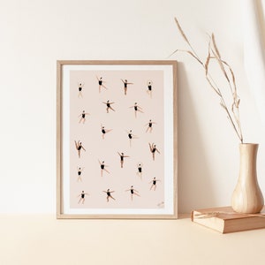 May include: A framed print with a pink background and a pattern of 20 dancers in black leotards. The dancers are in various poses, some are jumping, some are stretching, and some are holding their arms up in the air.
