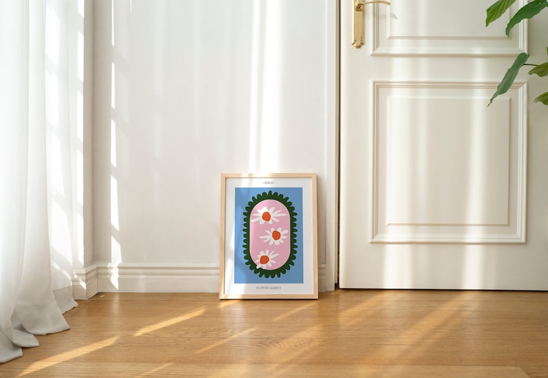 May include: A framed print with a light blue background and a pink oval shape with three white flowers with orange centers. The oval is surrounded by a green border. The print is titled "Flower Bouquet".