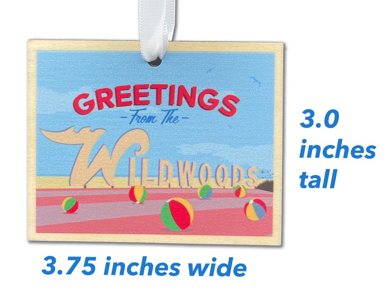 May include: A wooden ornament with a blue sky, beach, and the words "Greetings from the Wildwoods" in red and white. The ornament is 3.75 inches wide and 3 inches tall.