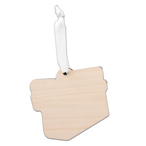 Puede incluir: Un adorno de madera en blanco con forma de caja de regalo con una cinta blanca. El adorno est&aacute; listo para ser personalizado.