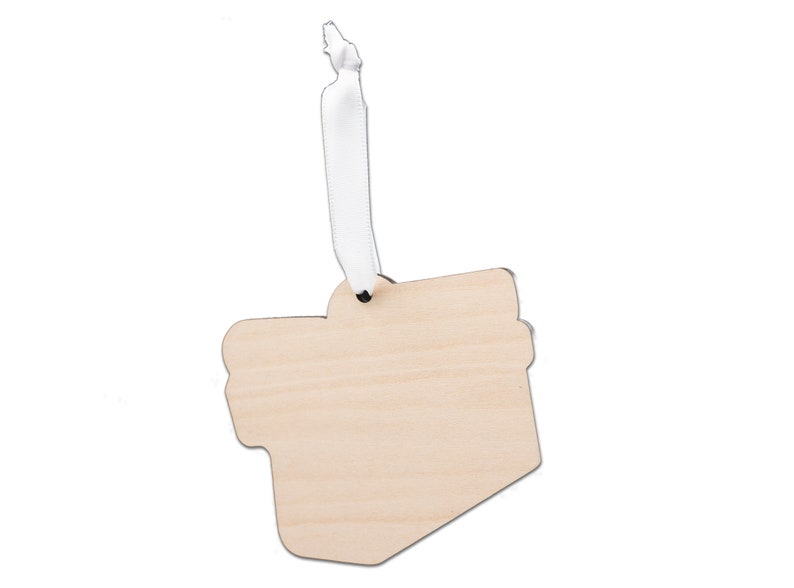 Puede incluir: Un adorno de madera en blanco con forma de caja de regalo con una cinta blanca. El adorno est&aacute; listo para ser personalizado.