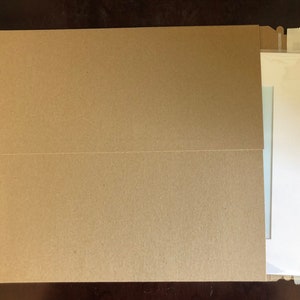 May include: A brown paper envelope with a white envelope inside. The white envelope is sealed with tape.