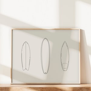 May include: A framed print with a minimalist line drawing of three surfboards on a white background.