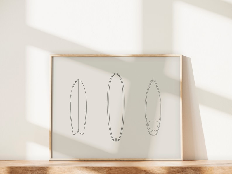 May include: A framed print with a minimalist line drawing of three surfboards on a white background.