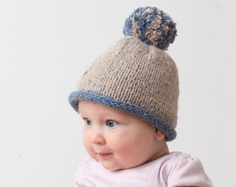 Winter cap for child 0-1 years old. Beige and navy blue beanie with pom-pom for baby made of tweed yarn.