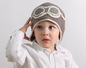 Un gorro de piloto para pequeños aficionados a la aviación o a los coches de 2 a 4 años, hecho de lana merino. Cálido, cubre las orejas y es perfecto para el invierno.