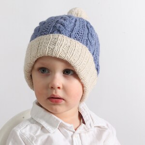 A classic, warm, soft children&#39;s cap with a pom-pom. Made from a blend of wool and alpaca. Blue, very warm, covers the ears.